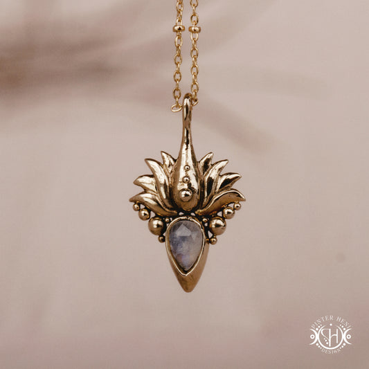 Hand-carved Agave pendant inspired by desert plant structure, sculptural botanical necklace in brass, on a beige background