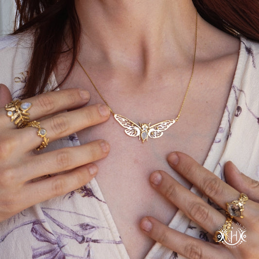 Handcrafted nature inspired gold jewelry, worn on a person.