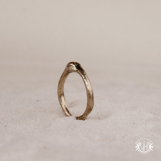 Cairn Ring handmade sandcast brass ring with clustered textured top, rustic ancient-inspired sculptural form, in sand.