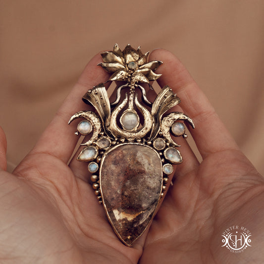 Large brass statement pendant with crystals and gemstones arranged in a crown-like sculptural form, Ishtar’s Oasis necklace.