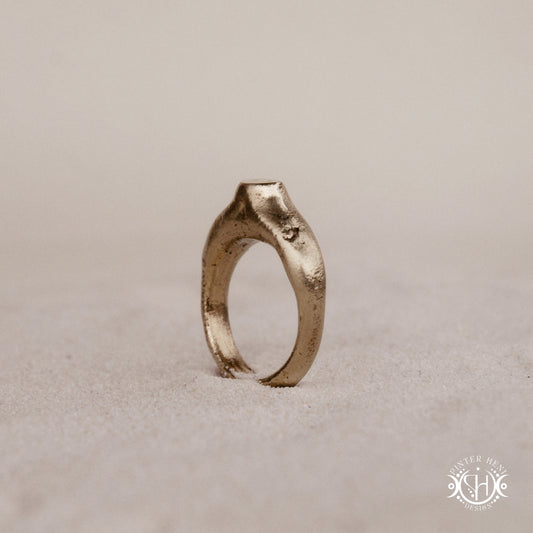 Monolith Ring handmade sandcast brass ring with raised vertical sculptural top, primitive and ancient-inspired form, in sand.
