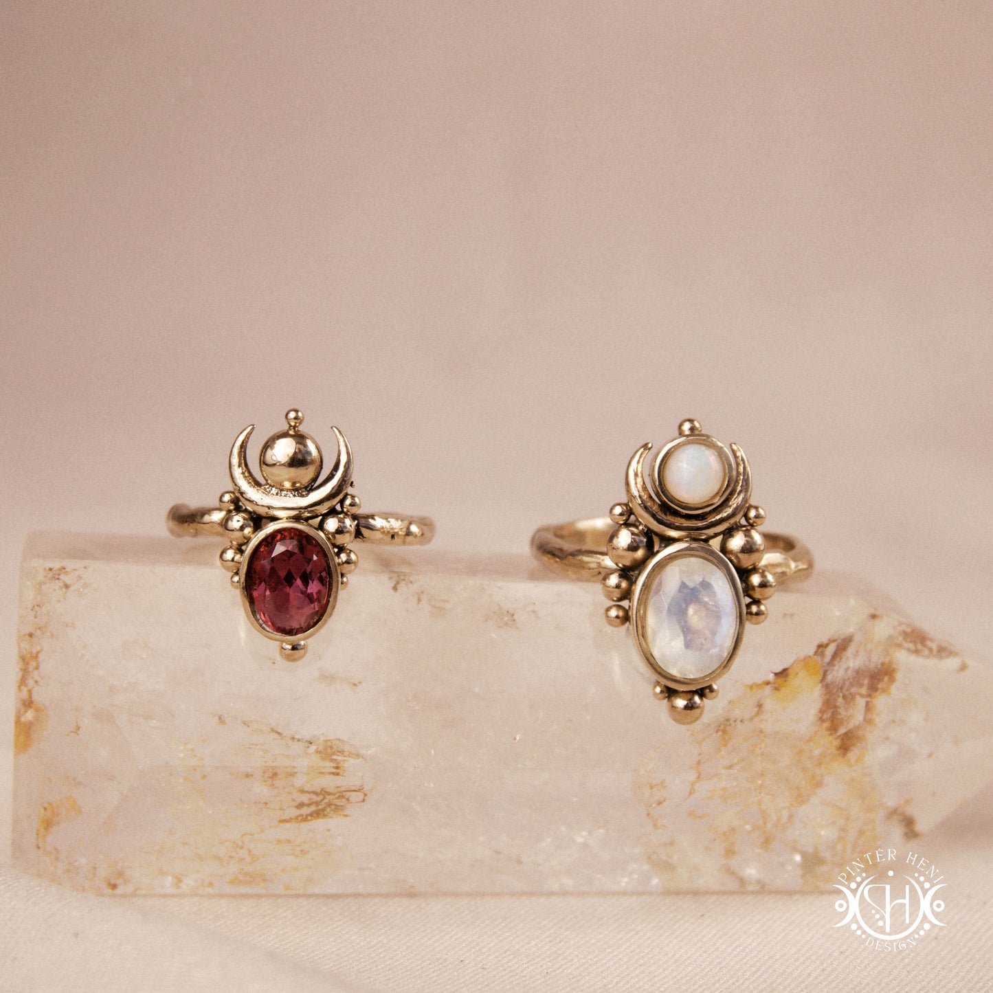 Hand-carved Nyx rings with opal, moonstone and garnet, on crystal.