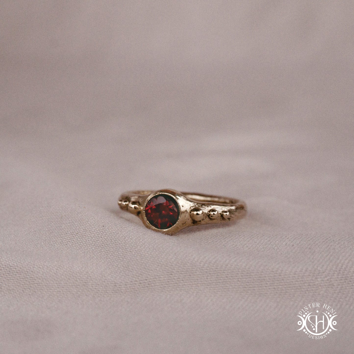 Star Cluster Ring with garnet and surrounding bead details in handcrafted metal