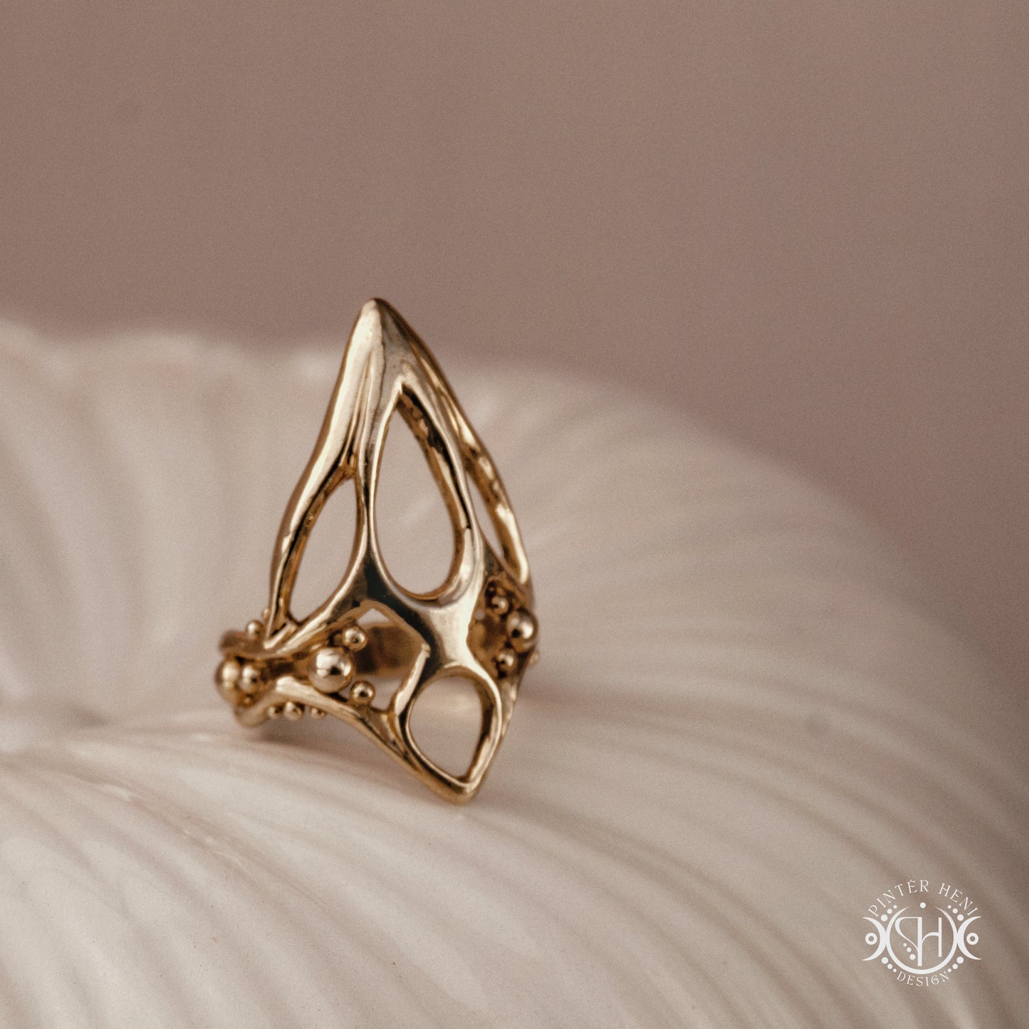 Void Ring open sculptural axial handmade ring with negative space organic structure, on ceramic surface.