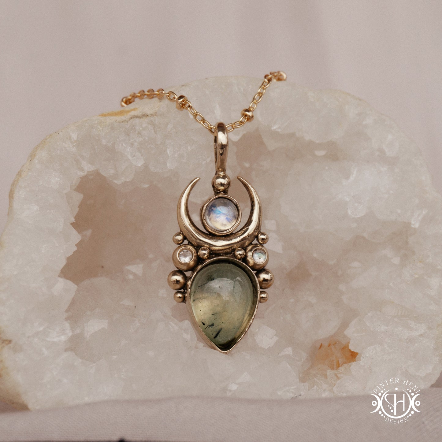 Brass Moon pendant with prehnite and moonstone, on crystal