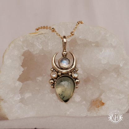 Brass Moon pendant with prehnite and moonstone, on crystal