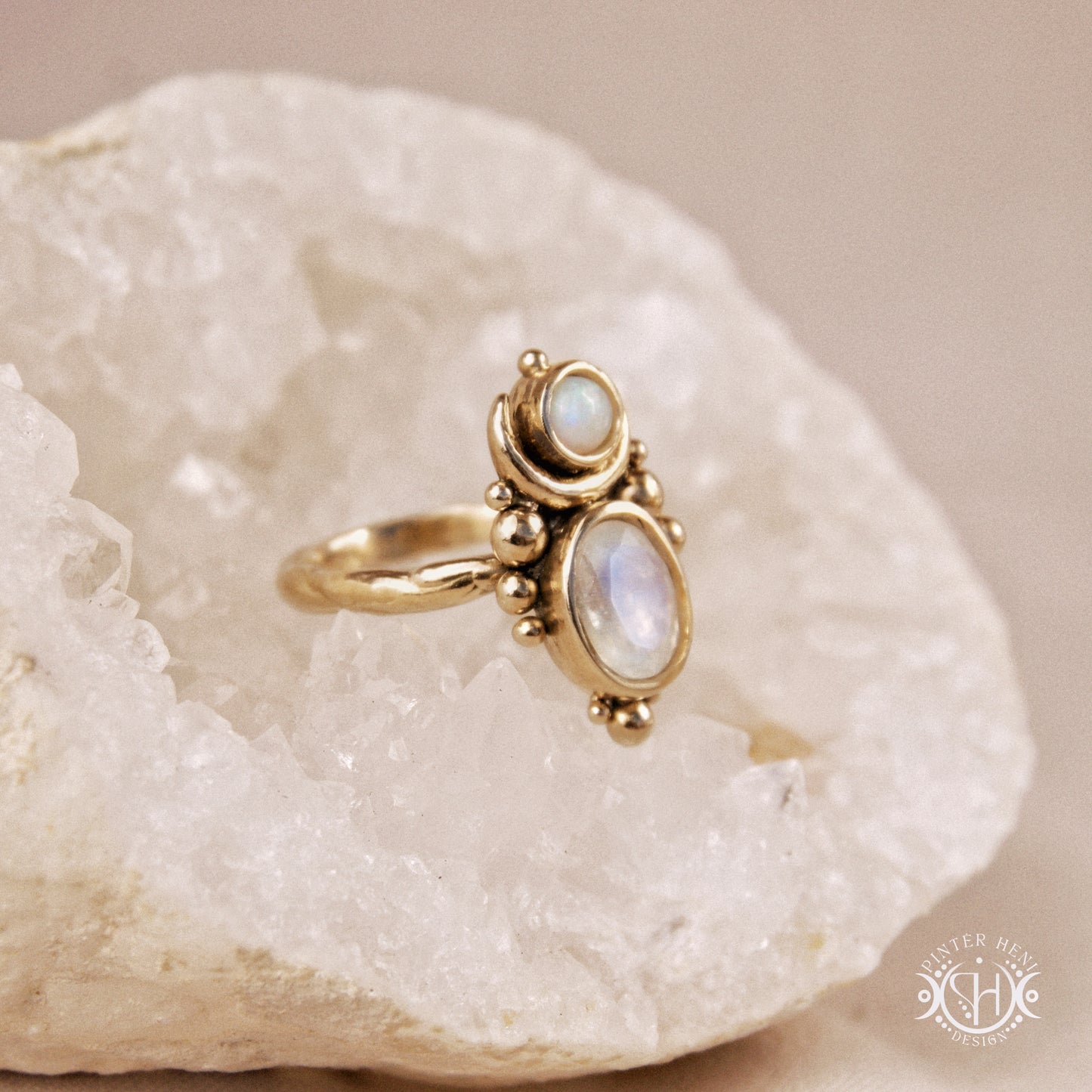 Hand-carved Nyx ring with opal and moonstone in brass, sculptural crescent design, on crystal.
nyx-ring-large-scale-moonstone-opal-close