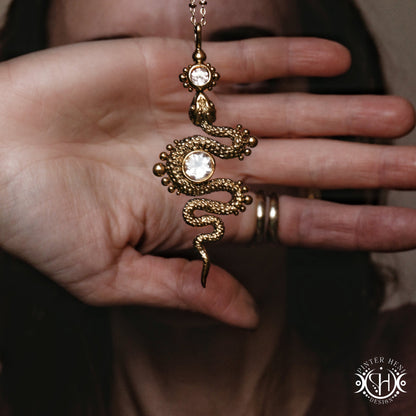 Decorative snake-shaped pendant with morganite on a person