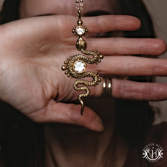 Decorative snake-shaped pendant with morganite on a person