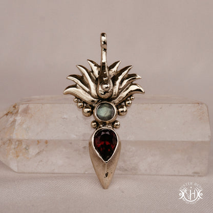 Handmade Agave pendant with garnet stone, sculptural desert-inspired botanical necklace, on crystal.