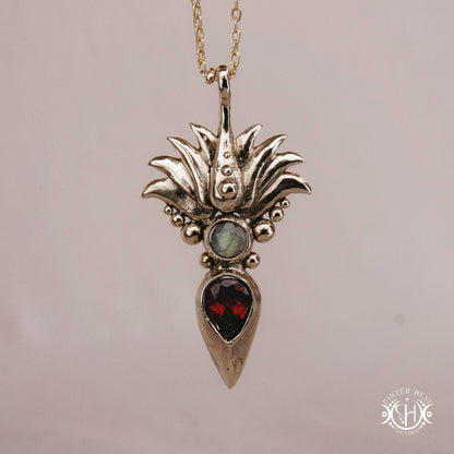 Handmade Agave pendant with garnet stone, sculptural desert-inspired botanical necklace.