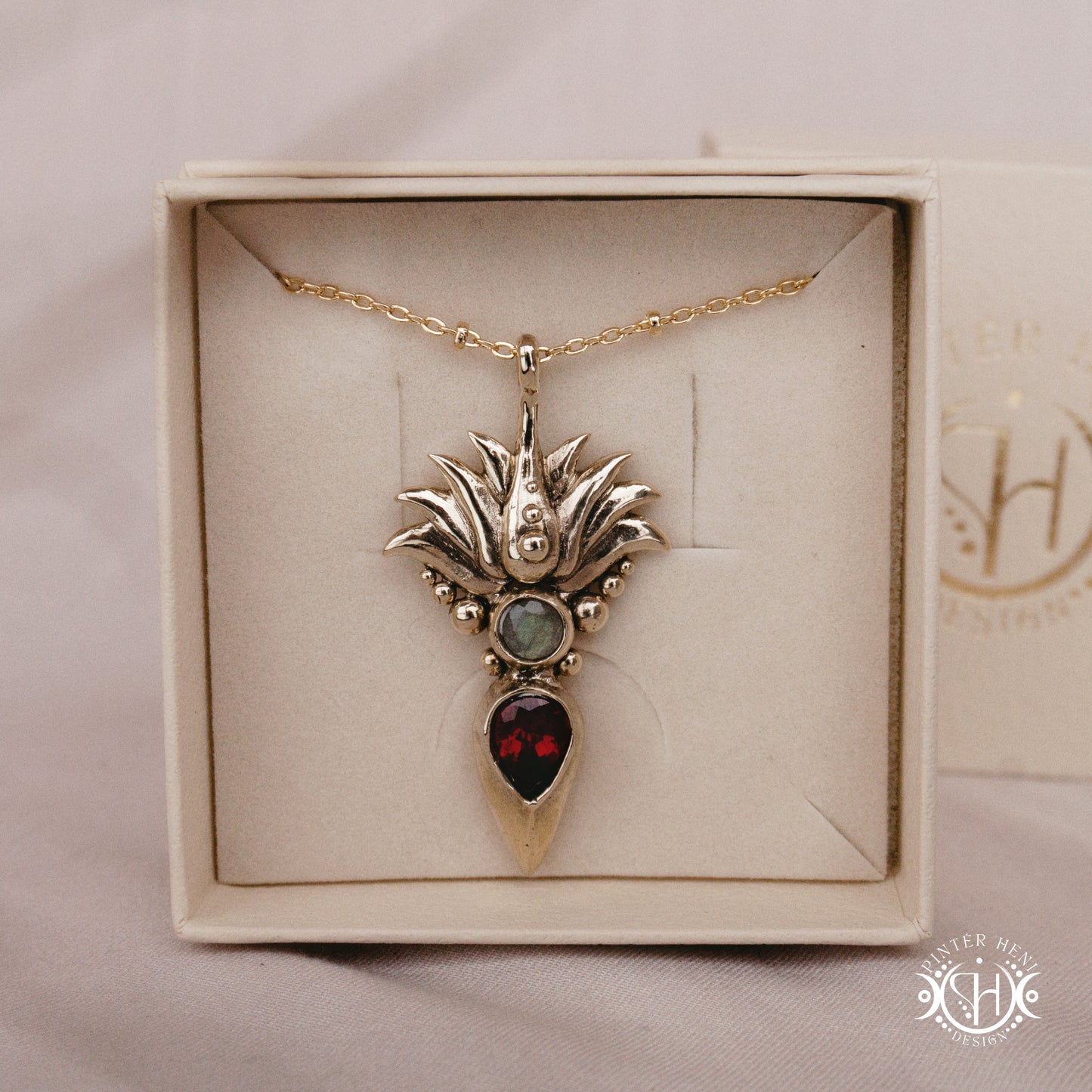 Handmade Agave pendant with garnet stone, sculptural desert-inspired botanical necklace, in branded jewelry box.