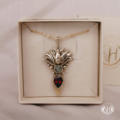 Handmade Agave pendant with garnet stone, sculptural desert-inspired botanical necklace, in branded jewelry box.