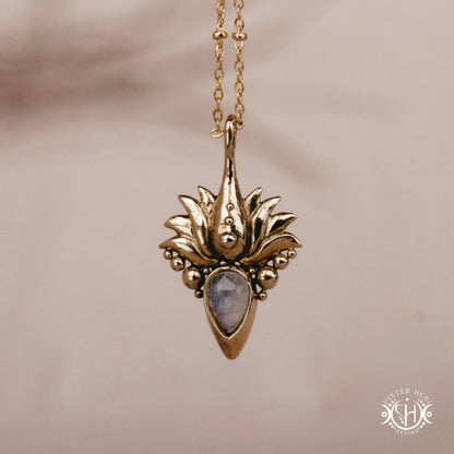 Hand-carved Agave pendant inspired by desert plant structure, sculptural botanical necklace in brass, on a beige background