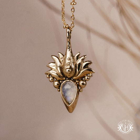 Hand-carved Agave pendant inspired by desert plant structure, sculptural botanical necklace in brass, on a beige background