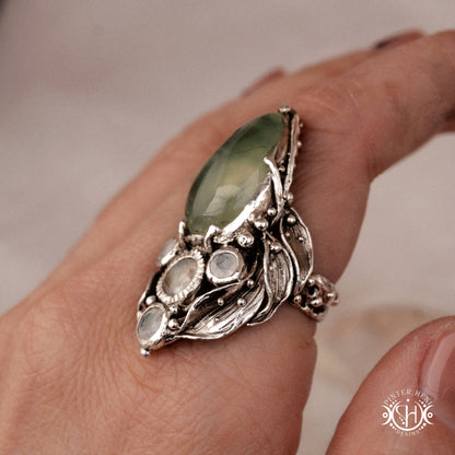 One-of-a-kind sterling silver ring with pear-shaped prehnite and moonstones in vertical sculptural setting.