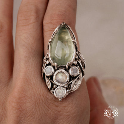 One-of-a-kind sterling silver ring with pear-shaped prehnite and moonstones in vertical sculptural setting.