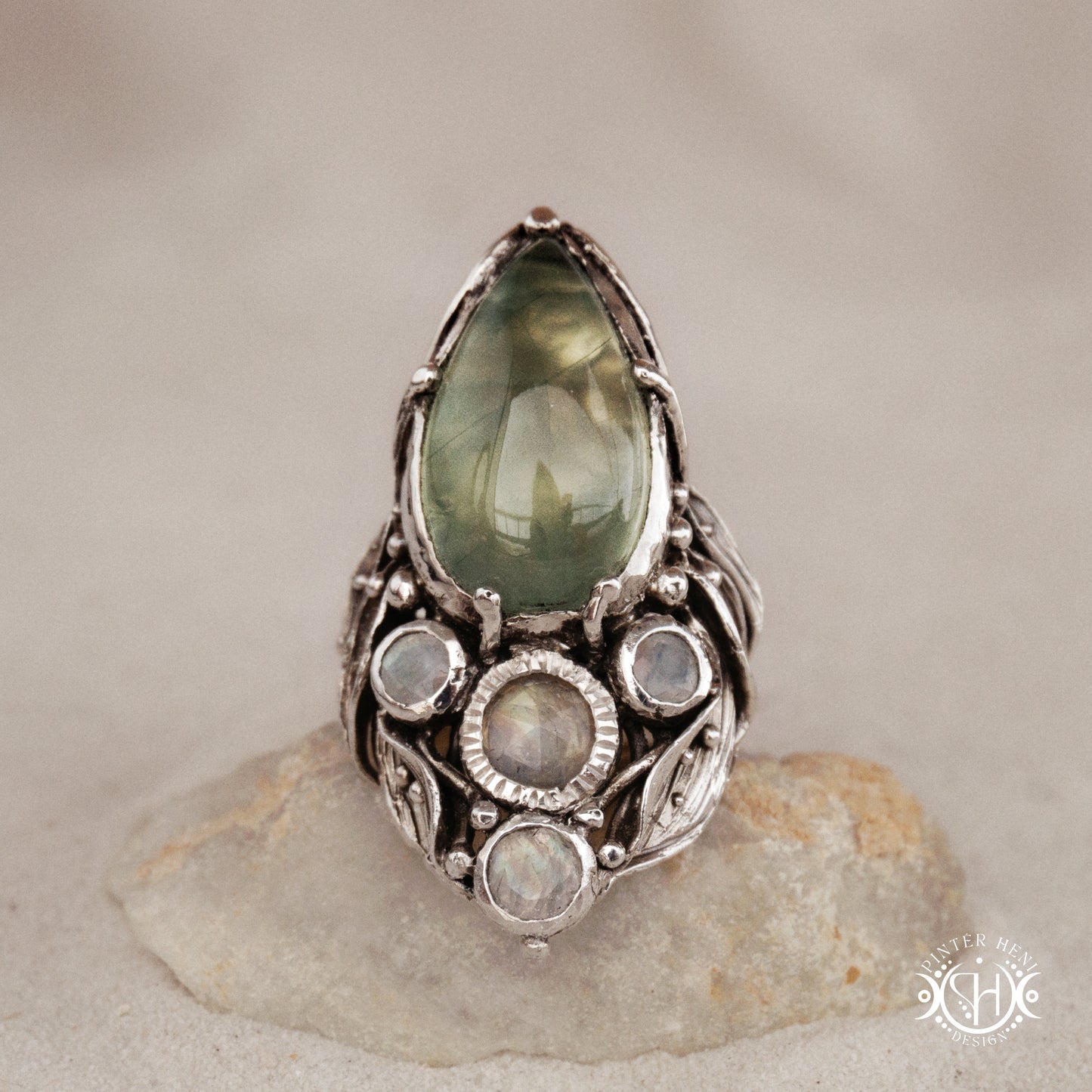 One-of-a-kind sterling silver ring with pear-shaped prehnite and moonstones in vertical sculptural setting.