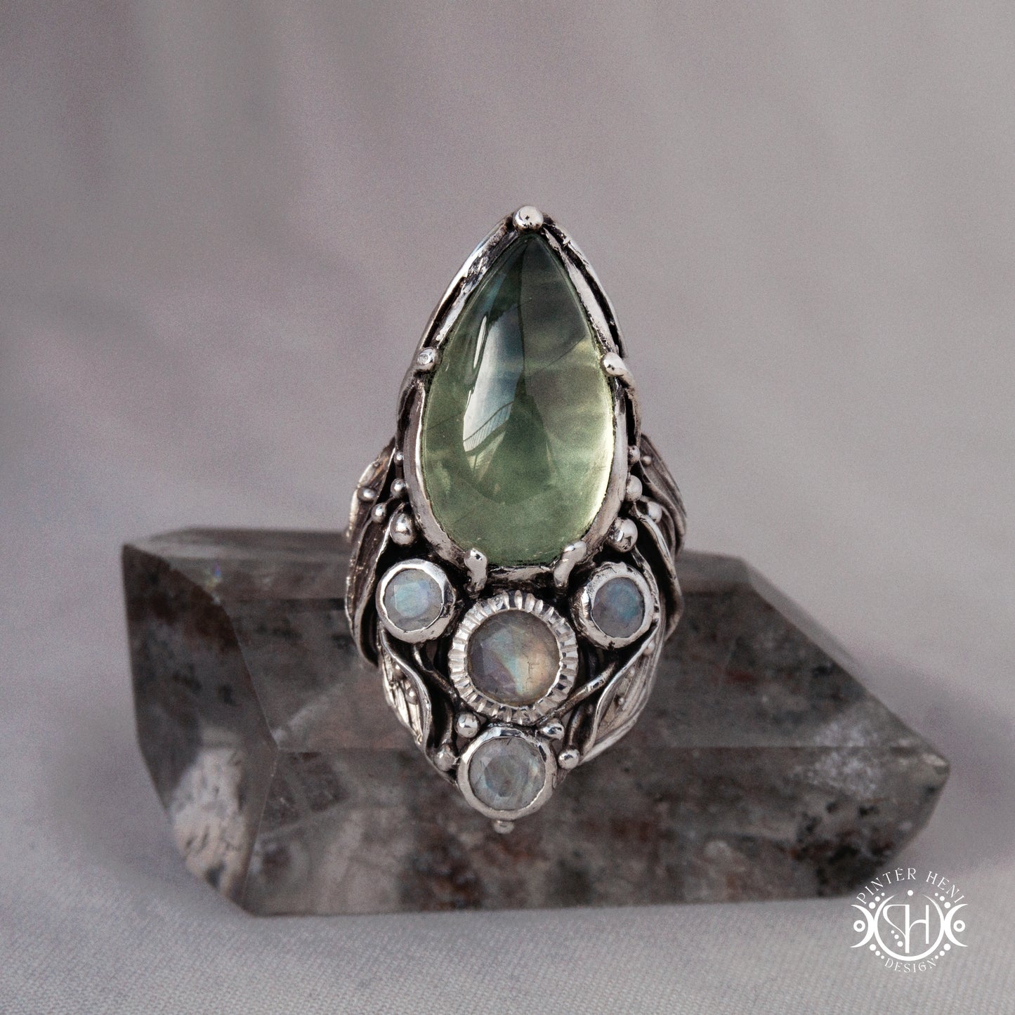 One-of-a-kind sterling silver ring with pear-shaped prehnite and moonstones in vertical sculptural setting.