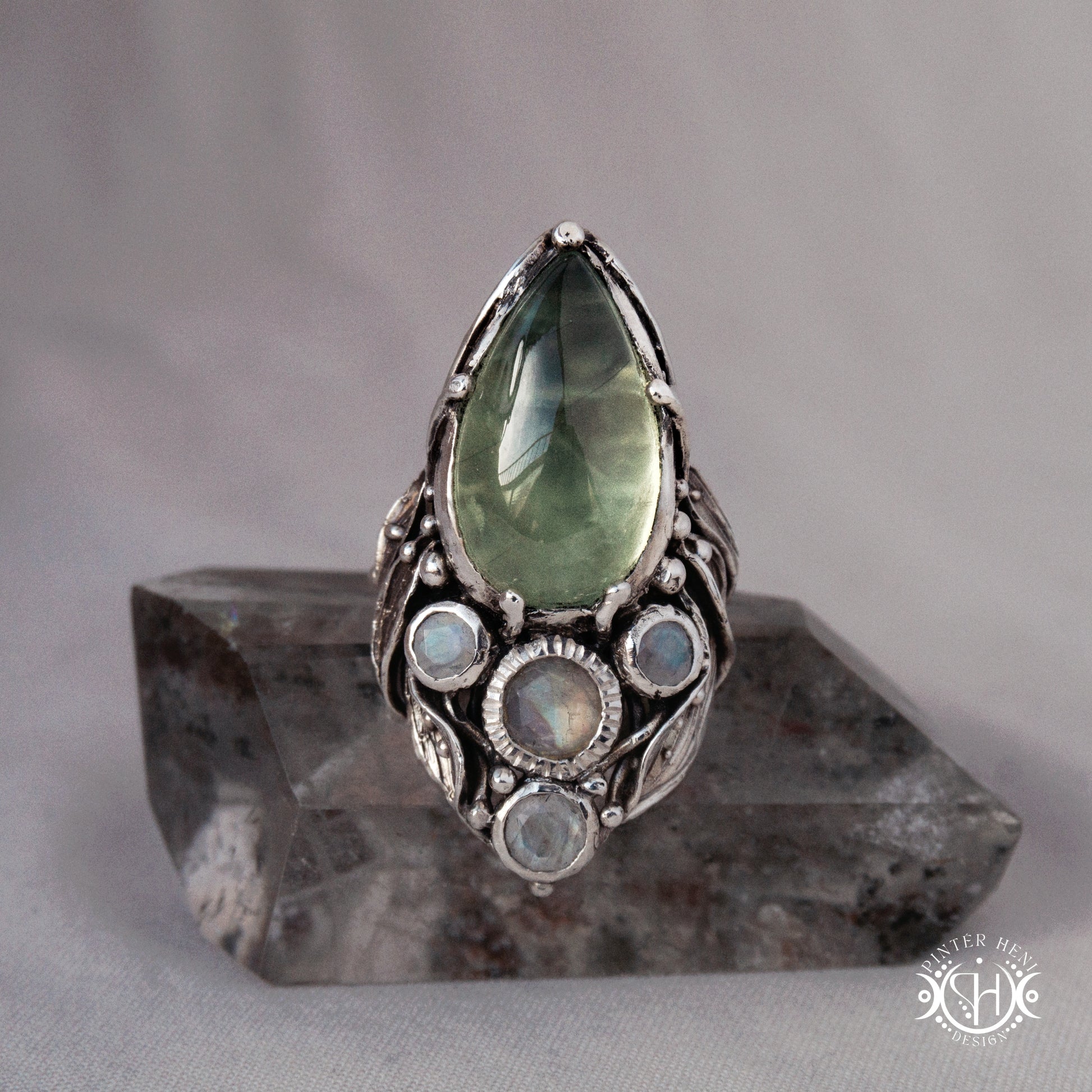 One-of-a-kind sterling silver ring with pear-shaped prehnite and moonstones in vertical sculptural setting.