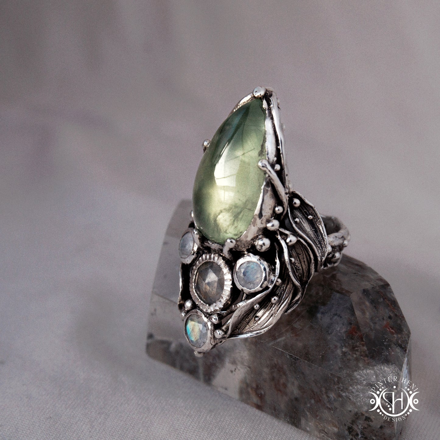 One-of-a-kind sterling silver ring with pear-shaped prehnite and moonstones in vertical sculptural setting.