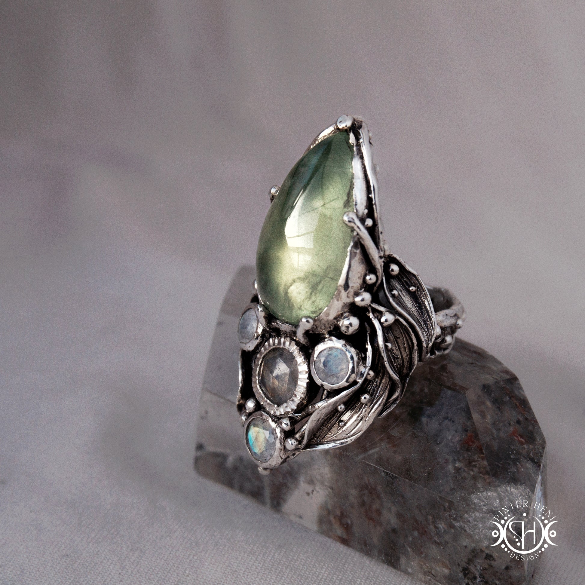 One-of-a-kind sterling silver ring with pear-shaped prehnite and moonstones in vertical sculptural setting.