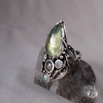 One-of-a-kind sterling silver ring with pear-shaped prehnite and moonstones in vertical sculptural setting.