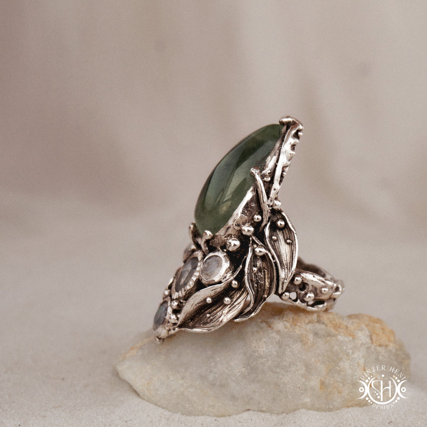 One-of-a-kind sterling silver ring with pear-shaped prehnite and moonstones in vertical sculptural setting.