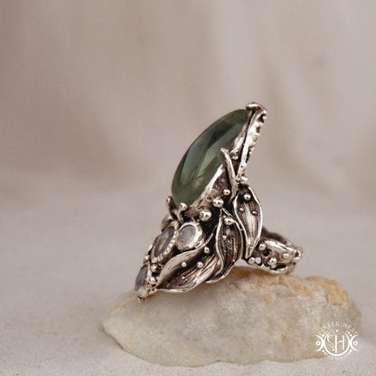 One-of-a-kind sterling silver ring with pear-shaped prehnite and moonstones in vertical sculptural setting.