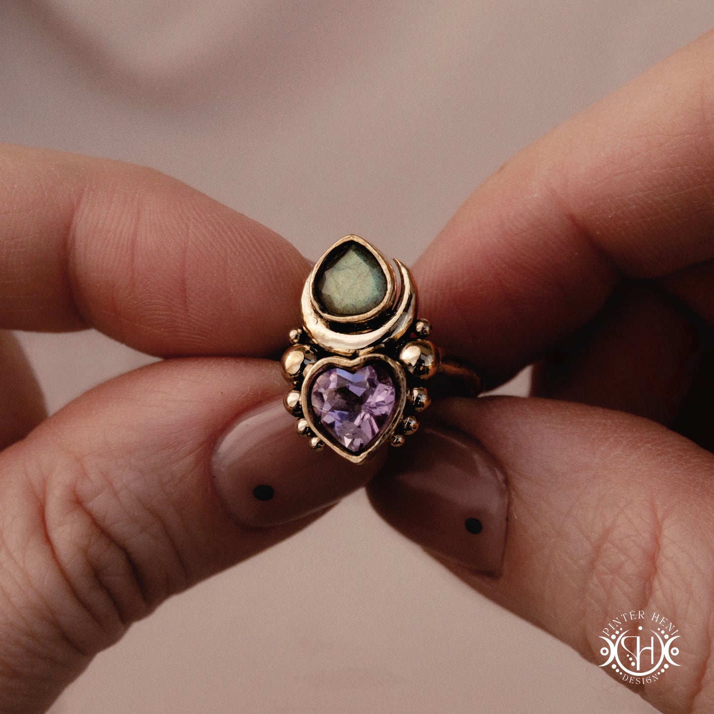 Sculptural handmade Aphrodite ring with amethyst and labradorite, held in hand