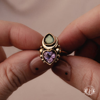 Sculptural handmade Aphrodite ring with amethyst and labradorite, held in hand
