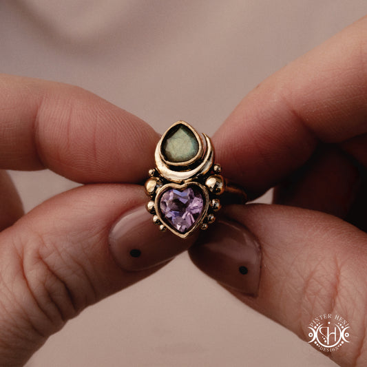 Sculptural handmade Aphrodite ring with amethyst and labradorite, held in hand