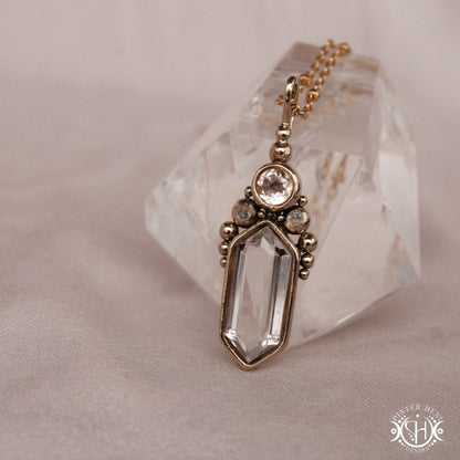 Handmade brass pendant with clear quartz and morganite, side view