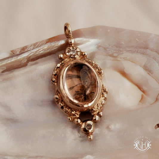 Hand-shaped brass pendant with lodolite quartz and moonstone, sculptural artisan necklace from the Asteria collection.