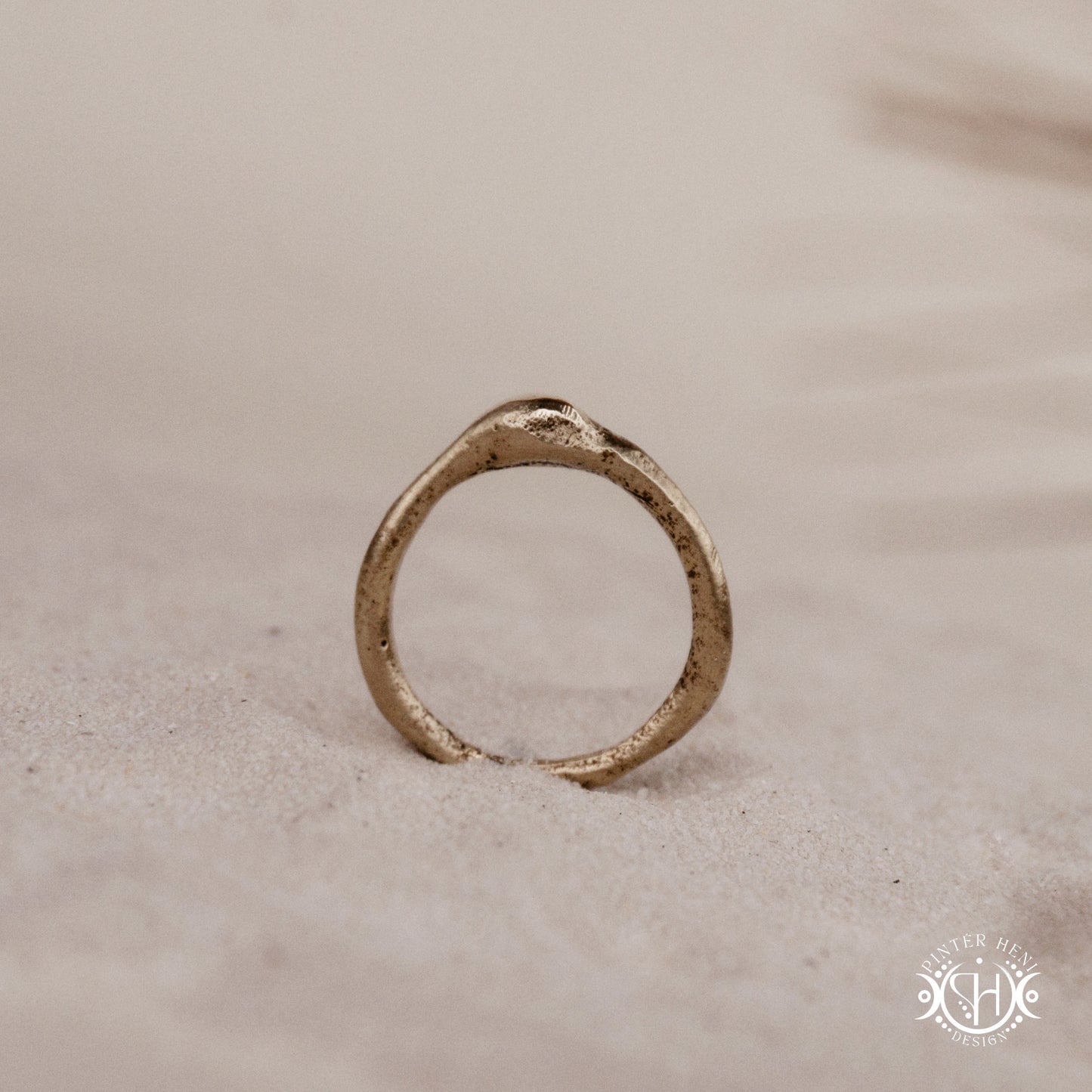 Cairn Ring handmade sandcast brass ring with clustered textured top, rustic ancient-inspired sculptural form, in sand.