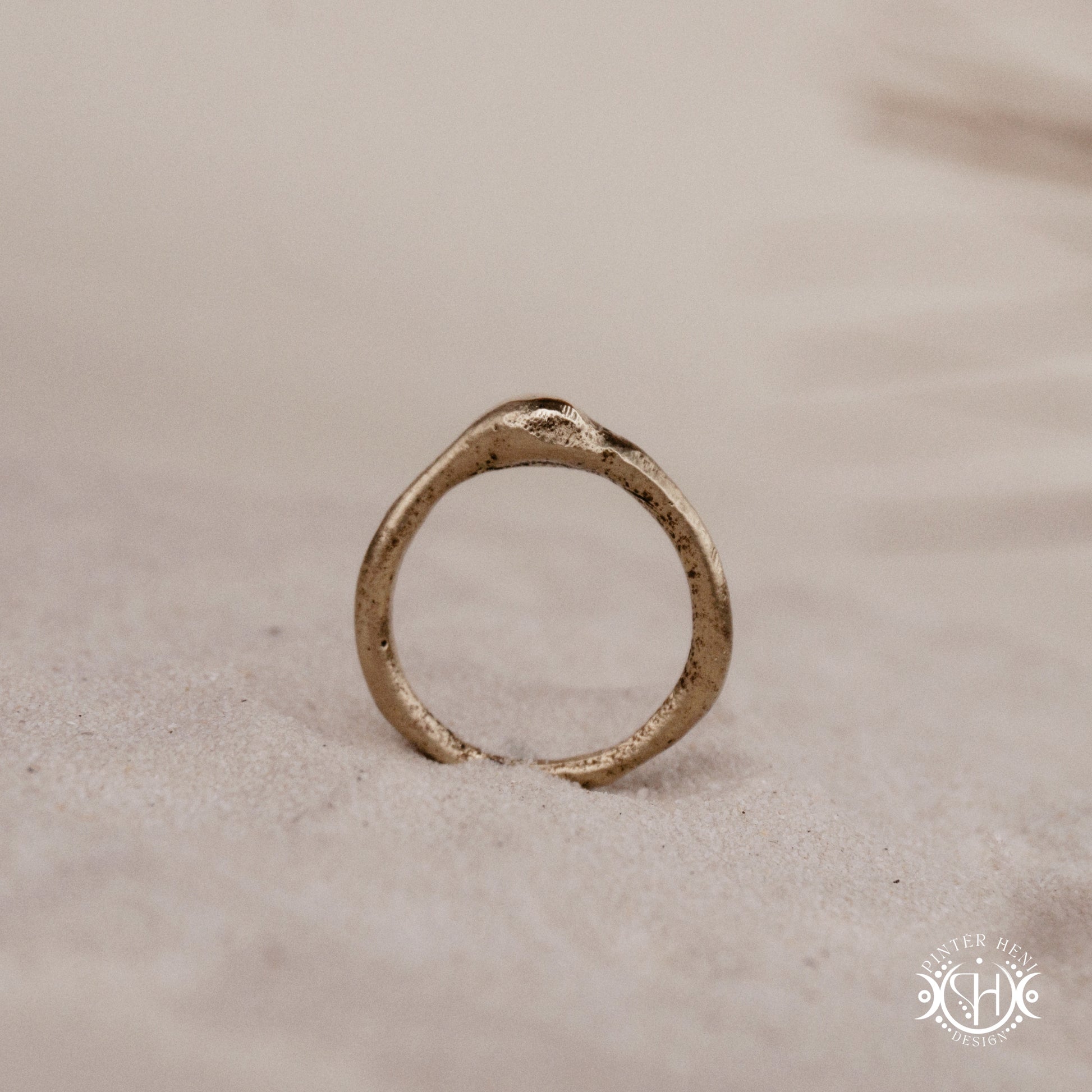 Cairn Ring handmade sandcast brass ring with clustered textured top, rustic ancient-inspired sculptural form, in sand.