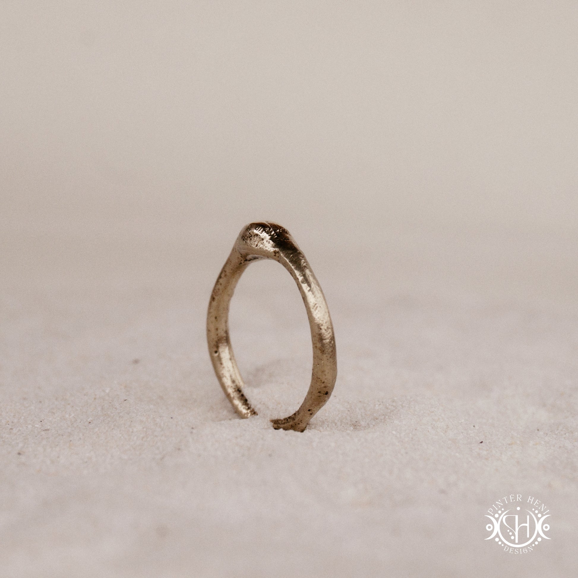 Cairn Ring handmade sandcast brass ring with clustered textured top, rustic ancient-inspired sculptural form, in sand.