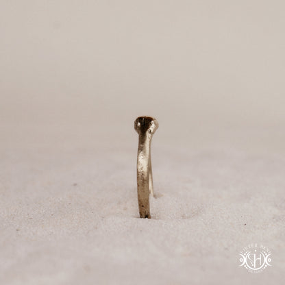 Cairn Ring handmade sandcast brass ring with clustered textured top, rustic ancient-inspired sculptural form, in sand.