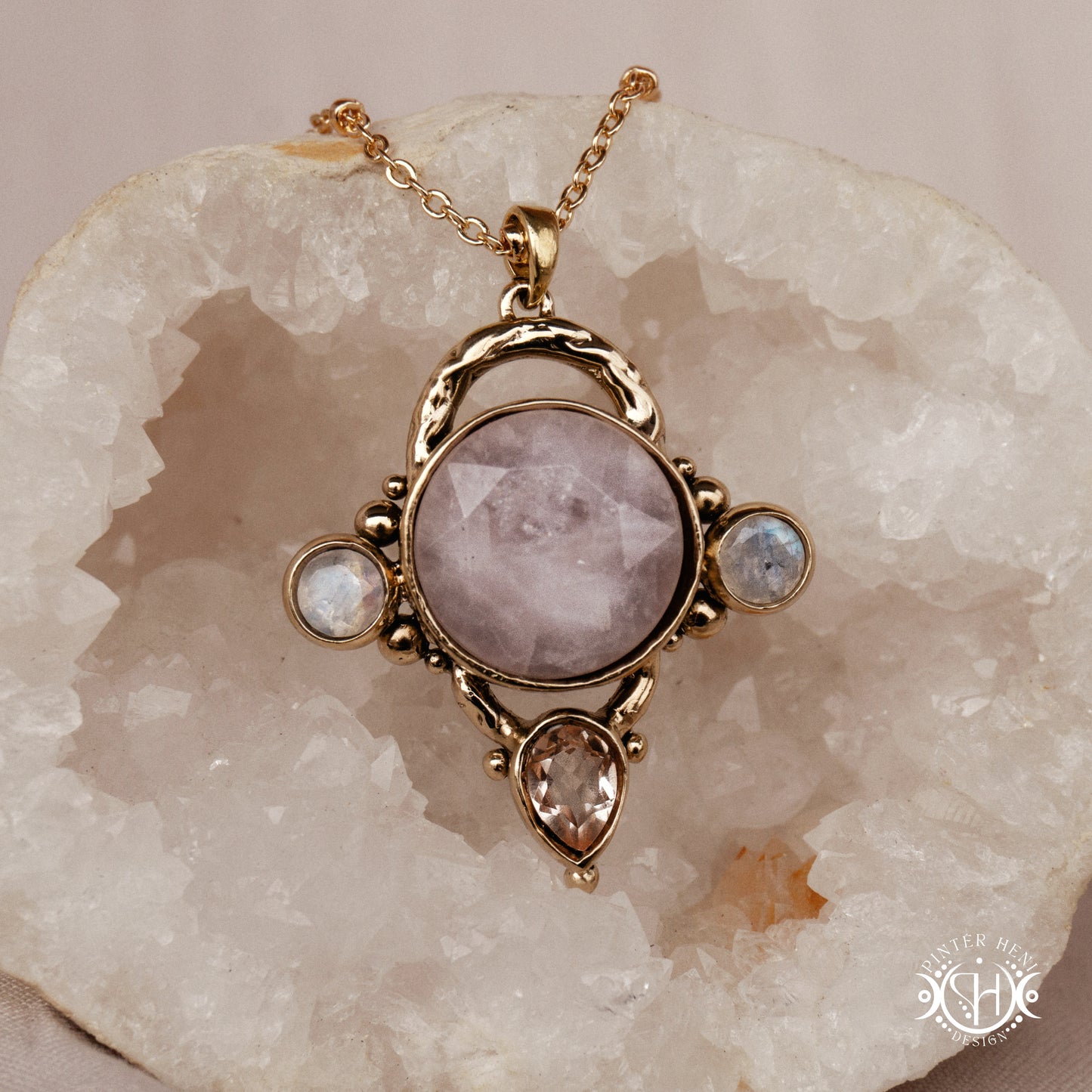 Handmade brass pendant with moonstone, morganite and rose quartz, on a crystal background