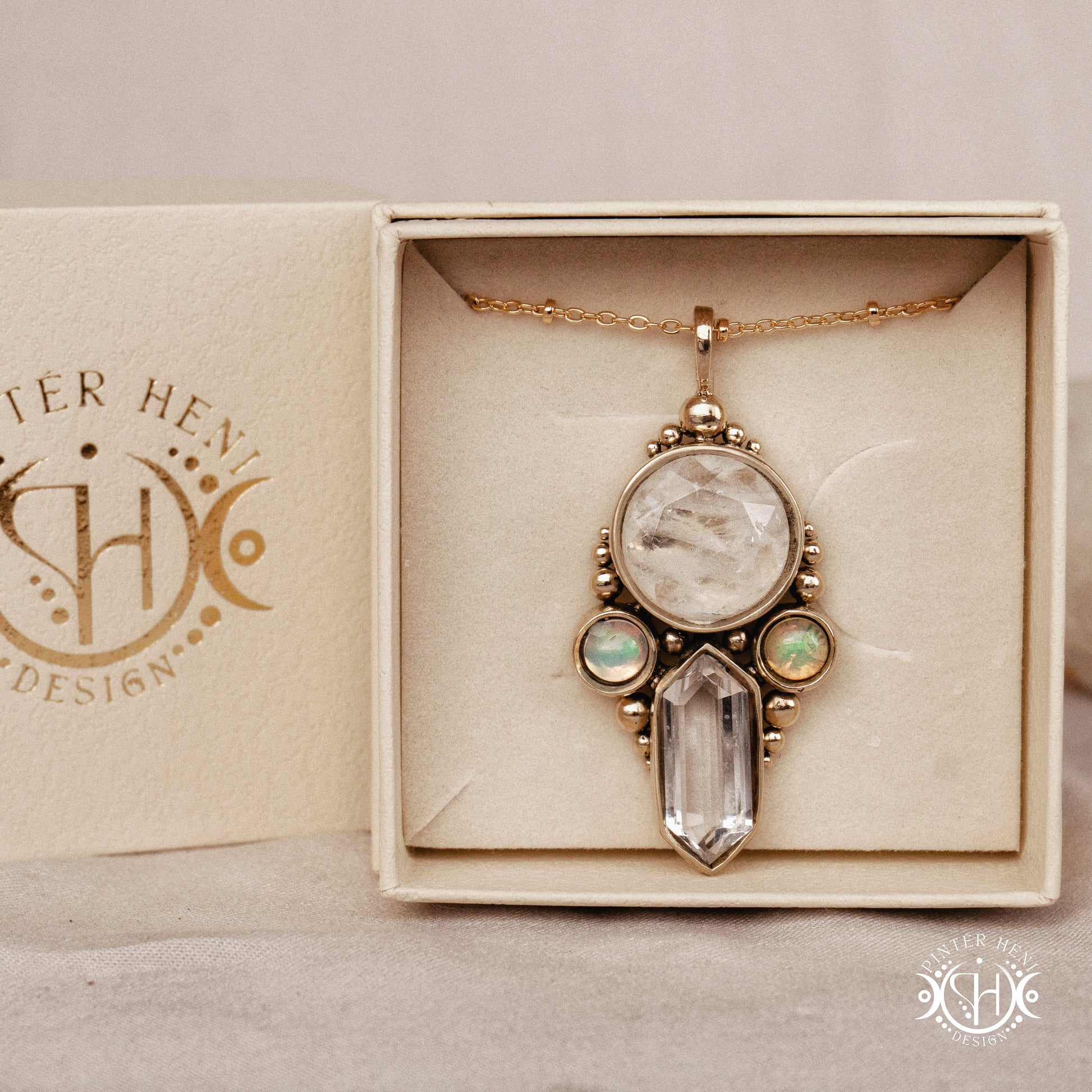 Brass pendant with clear quartz and opal stones, in branded jewelry box.