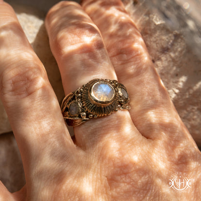 One-of-a-kind brass ring with three rainbow moonstones and sculptural carved band.
