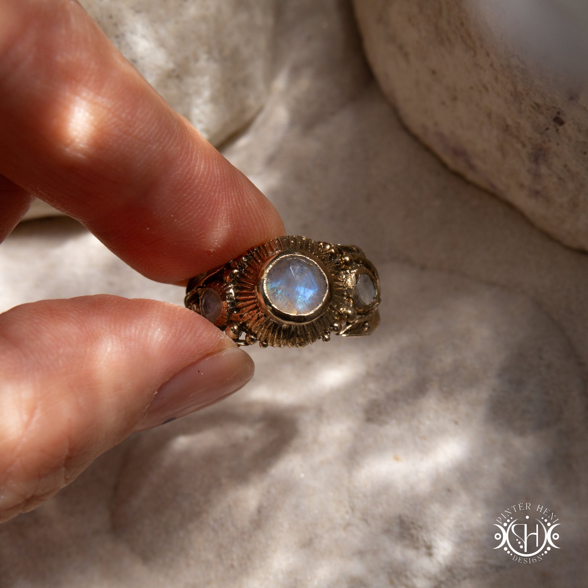 One-of-a-kind brass ring with three rainbow moonstones and sculptural carved band.