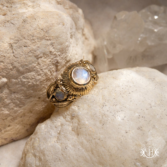One-of-a-kind brass ring with three rainbow moonstones and sculptural carved band.