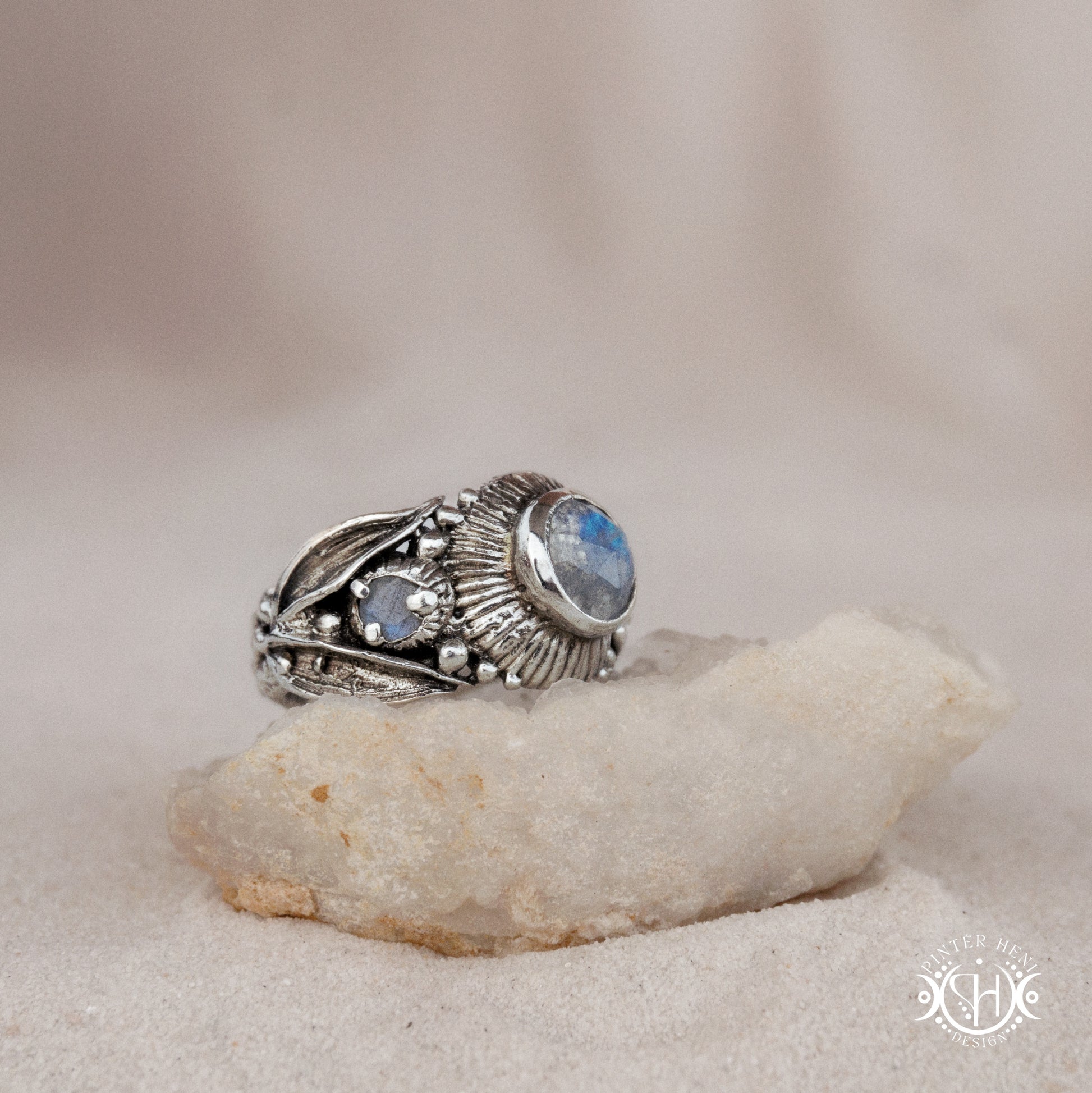 One-of-a-kind sterling silver ring with three rainbow moonstones and sculptural carved band.