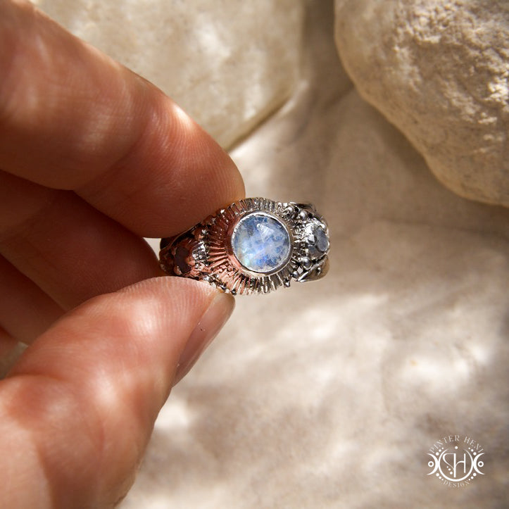 One-of-a-kind sterling silver ring with three rainbow moonstones and sculptural carved band.