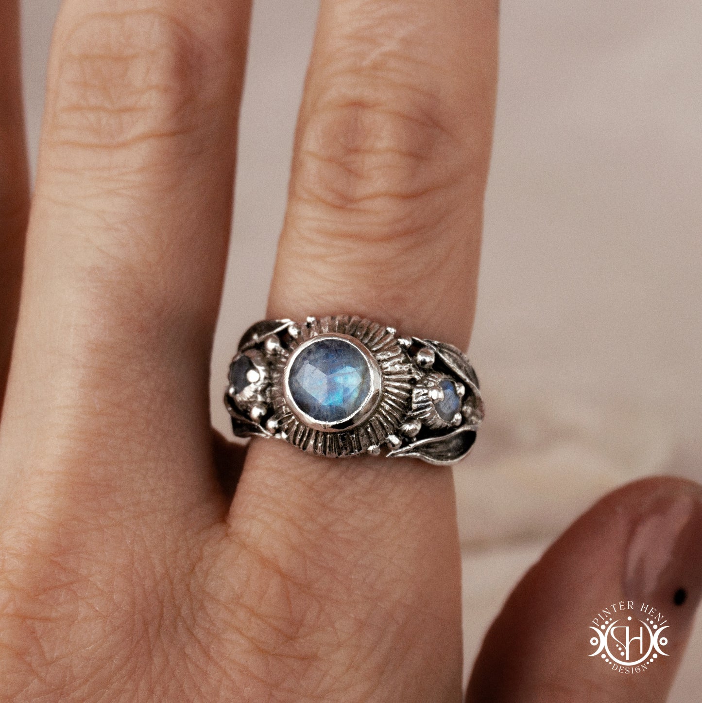 One-of-a-kind sterling silver ring with three rainbow moonstones and sculptural carved band.