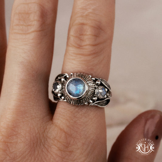One-of-a-kind sterling silver ring with three rainbow moonstones and sculptural carved band.