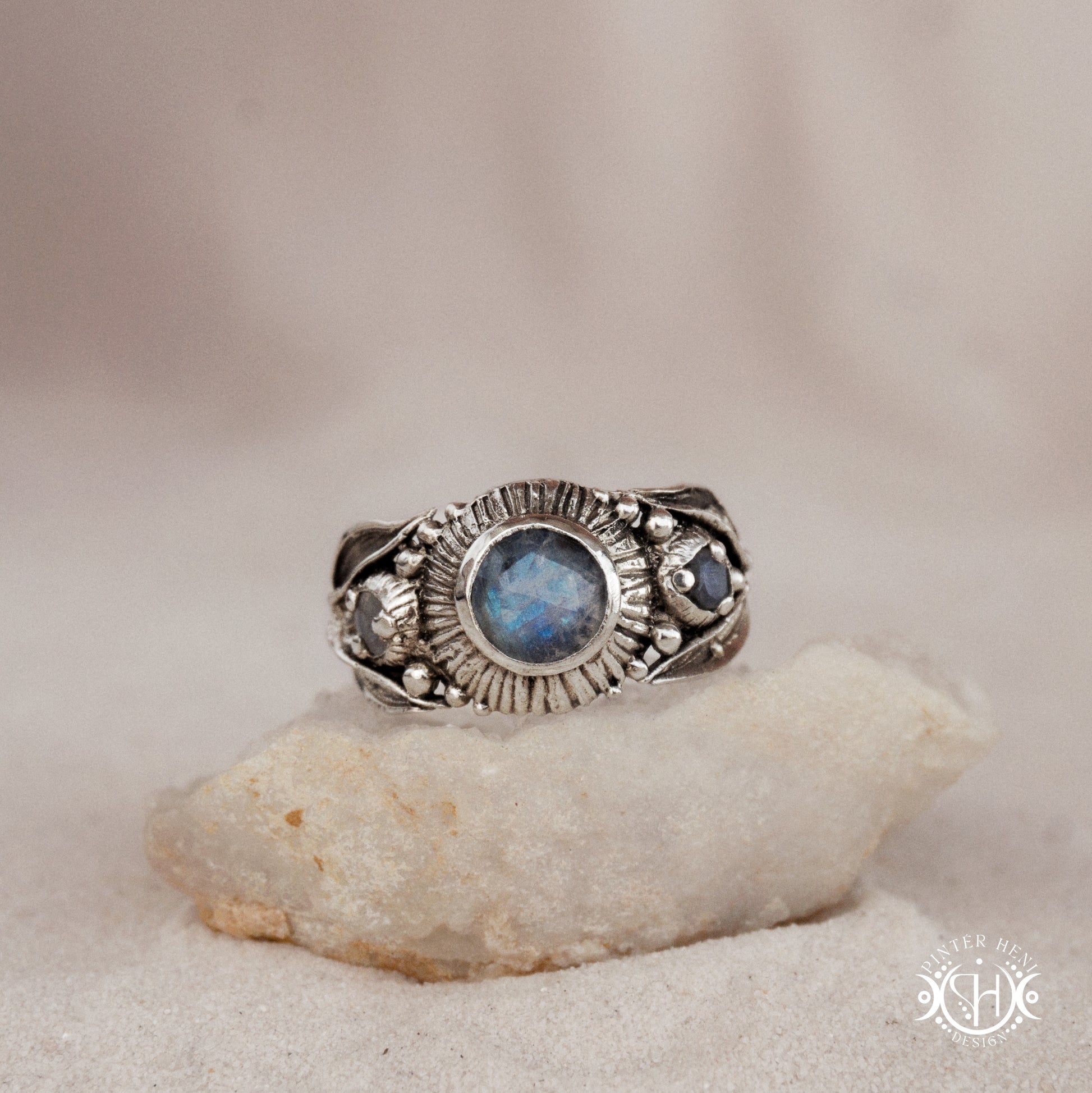 One-of-a-kind sterling silver ring with three rainbow moonstones and sculptural carved band.