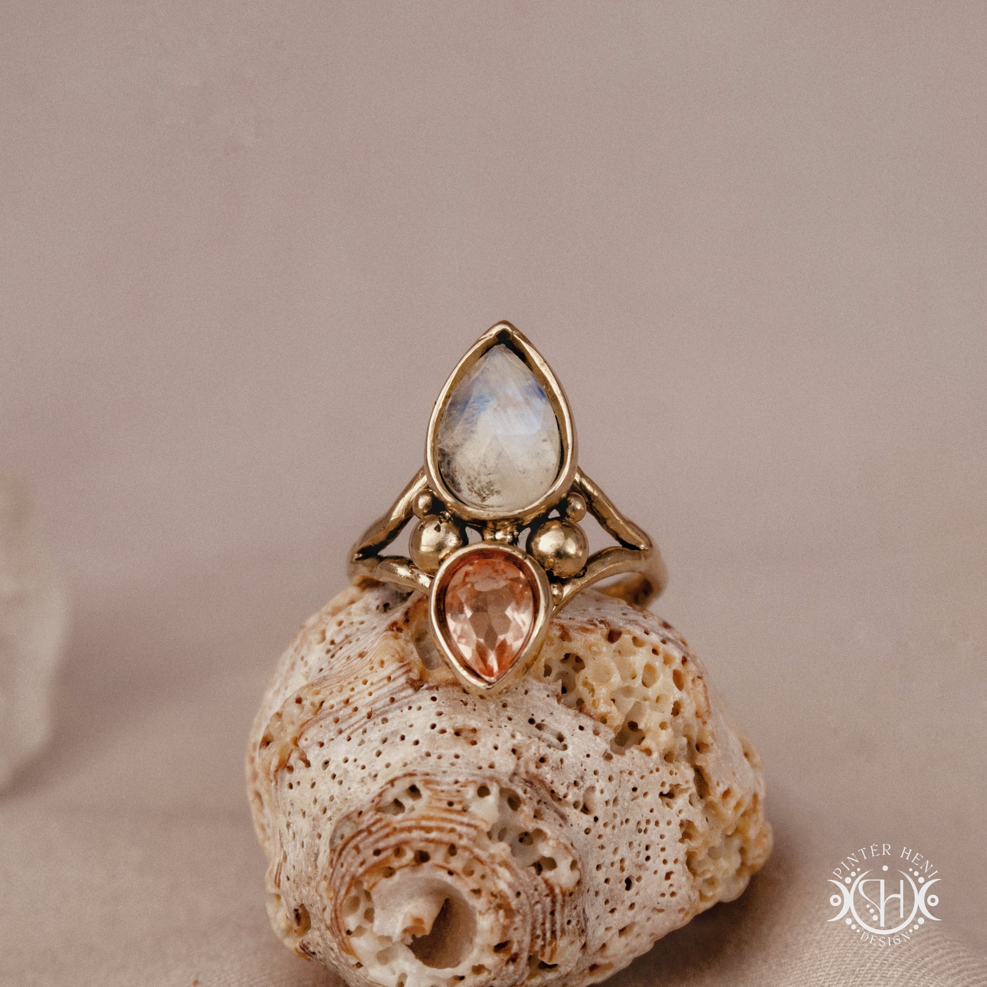 Handmade Harmonia ring with moonstone in symmetrical sculptural setting, on a shell.
