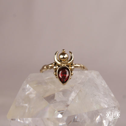 Handmade small scale Hecate ring with garnet in sculptural feminine design, on crystal